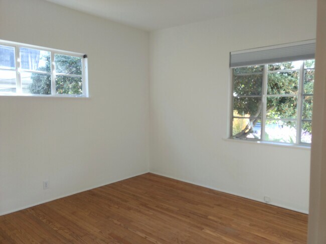 Bedroom with picture windows and hardwood floors - 715 Pacific St