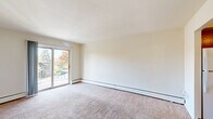 Located at 519 Williams Rd in King of Prussia, PA, this one-bedroom, one-bathroom residence offers a practical and comfortable layout across a single floor. The living room is bright and open, featuring wall-to-wall carpeting, a sliding glass door that fills the space with natural light, and direct access to a private balcony overlooking the tree-lined community grounds. A wall-mounted air conditioning unit and baseboard heating provide year-round climate control. The hallway connects the main living areas and leads to three closets, offering generous storage throughout. The bedroom is a comfortable size, carpeted, and equipped with a window dressed with blinds and its own wall AC unit, ensuring a quiet and climate-controlled retreat. The kitchen is efficiently designed with warm oak cabinetry, tile backsplash, granite-look countertops, and white appliances including a refrigerator, electric range, and dishwasher, all set on durable tile flooring. The bathroom features wood-look flooring, a white vanity with cabinet storage, a lighted medicine cabinet mirror, and clean, neutral finishes. The building is set within a landscaped community with ample parking and mature trees, providing a pleasant residential atmosphere.
