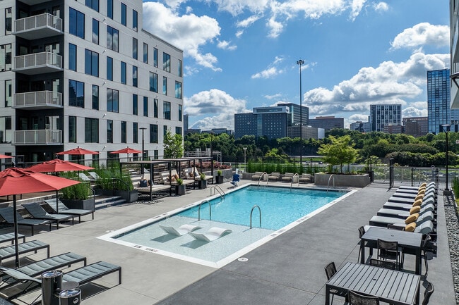 Swimming pool and cabana seating with skyline views - AMLI Atlantic Station