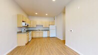 Located at 560 Humboldt Ave N in Minneapolis, Minnesota, this single-floor unit offers a clean, functional layout with a bright and neutral aesthetic throughout. The open kitchen is a standout feature, equipped with light maple cabinetry offering ample storage, gray laminate countertops, a built-in dishwasher, a full-size refrigerator, an electric range, and a microwave. Light wood-style flooring runs through the kitchen and main living areas, giving the space a warm, cohesive feel. The living areas are bathed in natural light, with large windows that frame views of the surrounding neighborhood's greenery. Bedrooms are finished with plush carpet, crisp white walls, and generous closet space, including double-door closets for added storage convenience. The bathroom is neatly appointed with a full tub-shower combination and clean white fixtures. A dedicated utility room and multiple additional closets throughout the unit provide excellent organizational capacity. The overall design is modern and understated, with recessed lighting in the kitchen, consistent white trim, and neutral tones that create a calm, move-in-ready environment well-suited to comfortable everyday living.