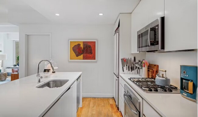 Open kitchen with white granite island (3 midcentury bar stools not pictured) - 90 William St