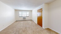 Located at 209 Pleasant Street in Melrose, MA, this one-bedroom, one-bathroom unit offers a thoughtfully arranged single-floor layout with a neutral, move-in-ready aesthetic throughout. The combined living and dining area is generously proportioned, featuring warm beige carpeting, cream-toned walls, and large windows that invite natural light and offer views of the surrounding neighborhood. Baseboard heating and a wall-mounted AC unit ensure year-round comfort. The bedroom is a well-sized retreat, also finished with plush carpeting and a large double bi-fold closet for ample storage. Two additional closets elsewhere in the unit provide further organizational flexibility. The kitchen features light hardwood-style flooring, white cabinetry, a gas range, and a full-size refrigerator, with direct access to the unit's entry door. A hallway connects the main living spaces to the bathroom, which is finished with classic warm-toned tile surrounding a full soaking tub and shower combination. The clean, understated design throughout the unit creates a cohesive and functional living environment well-suited for everyday comfort.