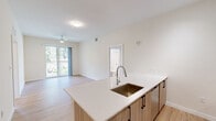 Located at 13901 SW 122nd Ave in Miami, FL, this well-appointed 2-bedroom, 2-bathroom residence offers a thoughtfully designed single-floor layout. The open-concept kitchen serves as the heart of the home, showcasing a large white quartz peninsula with an undermount sink, light wood cabinetry with matte black hardware, stainless steel appliances including a French door refrigerator, range, and microwave, plus track lighting overhead. The kitchen flows seamlessly into the living room, which is bathed in natural light from a sliding glass door that opens to a private outdoor area.

Light wood-tone luxury vinyl flooring runs throughout the entire residence, creating a cohesive and warm aesthetic. Both bedrooms are generously proportioned, with the primary bedroom offering direct access to its en-suite bathroom. Each bedroom features neutral cream walls, ceiling vents for climate control, and ample closet space. The two bathrooms are finished with tile flooring and include full tub-shower combinations with curved curtain rods, vanities, and clean white surrounds. A connecting hallway ties the layout together efficiently, completing this clean, modern Miami residence.