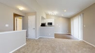 Located at 3419 Heritage Glen Dr in Grove City, Ohio, this two-bedroom, one-bathroom home offers a well-designed single-floor layout with a neutral color palette and a blend of practical finishes throughout. The open-concept living and kitchen area serves as the heart of the home, where vaulted ceilings lend a sense of openness and airiness. The kitchen features white cabinetry, granite-look countertops, black appliances including a refrigerator, electric range, and over-the-range microwave, all set atop wood-look plank flooring that extends into the living area. The living room is bright and inviting, with large windows and a sliding glass door that allows natural light to fill the space and provides outdoor views. Both bedrooms are carpeted and finished in warm neutral tones, with windows that bring in additional natural light. The spacious primary bedroom includes a closet with a sliding panel door and built-in shelving. The full bathroom is well-appointed with a white vanity, a tub-shower combination, and wood-look flooring that complements the rest of the home. A hallway connects the bedrooms and bathroom, with an additional closet providing convenient storage. Clean white trim and six-panel doors are consistent throughout the home.