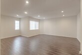 Located at 5555 Harold Way in the heart of Los Angeles, CA 90028, this single-floor unit offers a clean, modern interior with a well-considered layout. Rich, dark hardwood flooring runs throughout the main living areas, providing warmth and visual continuity across the open floor plan. Recessed lighting is installed throughout, ensuring consistent, even illumination in every room.

The spacious main living area is open and flexible, with crisp white walls, clean baseboards, and multiple entry points that connect seamlessly to adjacent rooms. A secondary room with vertical blinds allows for natural light while maintaining privacy, making it well-suited for use as a bedroom or home office.

The galley-style kitchen is efficiently designed, featuring white shaker cabinetry with brushed nickel hardware, granite-look countertops, a stainless steel sink, a gas range, and a full-size refrigerator. The light tile flooring in the kitchen provides a practical contrast to the hardwood found elsewhere. The overall layout, as revealed in the dollhouse view, presents a compact yet functional configuration with distinct living, sleeping, and cooking zones. The unit's neutral palette and updated finishes create a move-in-ready environment suited to a variety of lifestyles.