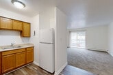 Located at 531 35th St in Des Moines, Iowa, this two-bedroom, one-bathroom unit offers a well-organized, single-floor layout designed for comfortable everyday living. The living room is a bright, open space featuring plush carpeting, a wall-mounted air conditioning unit, baseboard heating, and a sliding glass door that opens onto a private balcony, filling the room with natural light. Adjacent to the living area, the combined kitchen and dining space features warm oak cabinetry, light countertops, a double-basin sink, and white appliances including a coil-top range and full-size refrigerator, all set on durable hardwood-style flooring. Both bedrooms are carpeted and well-lit, each offering windows with blinds that provide natural light and outdoor views, along with baseboard heating for year-round comfort. The primary bedroom includes dedicated closet space, and the unit as a whole benefits from four closets total, offering generous storage throughout. The full bathroom is finished in a clean, all-white palette with a tub/shower combination, a vanity with sink, and hardwood-style flooring. Textured ceilings are present throughout, adding a classic residential character to the space overall.