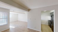 This single-floor residence offers a well-organized layout with a variety of functional spaces connected by a consistent design language of neutral tones and clean finishes throughout. The main living area is generously sized, featuring light hardwood-style flooring that runs throughout the common areas, textured ceilings, and a white-framed fireplace that serves as a focal point. A sliding glass door in the living room opens to an outdoor area and allows natural light to fill the space, complemented by multiple windows dressed with blinds. Exposed ceiling beams add a subtle architectural detail to the open-plan living and dining zones.

The kitchen is well-appointed with granite countertops, grey cabinetry, a classic white subway tile backsplash, and built-in appliances including a dishwasher. A peninsula counter provides a convenient transition between the kitchen and the adjacent dining or living area. The entryway welcomes residents with hardwood-style flooring and a built-in ledge detail along the wall.

The bedrooms offer plush carpeting, natural window light, and ample wall space, with one room featuring a built-in closet. Throughout the residence, the consistent use of white walls and neutral finishes creates a bright, cohesive atmosphere that is both practical and inviting.