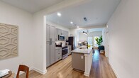 Located at 1588 Bloom St in Mount Pleasant, South Carolina, this single-floor residence offers a thoughtfully designed open-concept layout with contemporary finishes throughout. The kitchen serves as the heart of the home, featuring sleek gray shaker cabinetry, stainless steel appliances including a gas range and built-in microwave, a subway tile backsplash, and a central island with a granite countertop and undermount sink — ideal for both cooking and casual dining. Warm-toned hardwood flooring extends seamlessly from the kitchen through the living and dining areas, creating a cohesive, inviting flow. The dining area provides an intimate setting with clean white walls and ample space for a round table. The living room is bright and welcoming, benefiting from natural light and direct access to a glass door entrance. The bedrooms offer a calm retreat, each with plush carpeting, ceiling fans, and generous natural light from well-placed windows. The bathroom is elegantly appointed with granite countertops, white cabinetry, a large mirror, and a glass-enclosed walk-in shower. A dedicated laundry room with a full-size washer and dryer completes the practical amenities of this well-rounded Mount Pleasant residence.