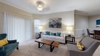 Located at 14165 Dunbritton Ln in Charlotte, NC, this single-story residence offers a well-organized layout designed for comfortable everyday living. The living room serves as the central gathering space, featuring elegant crown molding, plush carpeting, and a ceiling light fixture. Natural light enters through windows fitted with blinds, and a sliding glass door extends the room's connection to the outdoors.

Adjacent to the living area, a dedicated dining nook provides an intimate setting defined by chair-rail molding and crown molding details. The galley-style kitchen is equipped with stainless steel appliances, including a range, microwave, refrigerator, and dishwasher, complemented by granite-style countertops, white cabinetry, and wood-look flooring. A built-in pantry offers additional storage convenience.

The residence includes multiple bedrooms, each finished with soft carpeting and ceiling fans or light fixtures. At least one bedroom features a walk-in closet with built-in shelving. The bathrooms are finished with wood-look flooring, vanities with granite-style countertops, and shower-tub combinations, providing functional and clean design throughout the home.