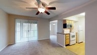 Located at Tally Square, this single-floor residence delivers a practical and comfortable layout thoughtfully designed for everyday living. The spacious living area is finished with plush wall-to-wall carpeting and features a ceiling fan with light fixture, providing both comfort and airflow. A large sliding glass door dressed with vertical blinds fills the room with natural light and offers access to the outdoors. The living area connects seamlessly to the kitchen through an open pass-through, enhancing the sense of openness throughout the home. The kitchen is equipped with light wood cabinetry, dark granite-style countertops, a full suite of white appliances including a refrigerator, electric range, dishwasher, and microwave, along with durable hardwood-style flooring. The bedrooms are generously sized with soft carpeting, ceiling fans or flush-mount lighting, and ample closet storage — including both standard and shelved closets. Natural light enters through windows fitted with vertical blinds. The bathroom is well-appointed with a wood vanity, granite-style countertop, a large wall mirror, and a full tub-shower combination, complemented by hardwood-style flooring. Overall, the space presents a clean, neutral palette with warm tones throughout.
