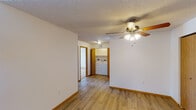 Located at 1930 49th St S in Fargo, North Dakota, this single-floor unit offers a practical and comfortable layout designed for everyday living. The main living area features durable hardwood-style flooring, a ceiling fan with light fixture, and a sliding glass door that floods the space with natural light and provides direct access to an outdoor patio, offering pleasant exterior views. Textured ceilings and warm wood-toned baseboards and trim are consistent throughout, lending a cohesive aesthetic to the interior. The kitchen is efficiently designed with warm oak cabinetry, a white electric range, and an over-the-range microwave. A dedicated laundry area is conveniently tucked within the unit, housing a full-size washer and dryer. The bedrooms are carpeted for comfort, each featuring baseboard heating and windows that bring in natural light. One bedroom includes a walk-in closet with built-in shelving, while another offers a sliding wood closet. The full bathroom is finished with tile flooring, warm wood cabinetry, a vanity, and a bathtub, with an additional half-bath offering wire shelving for storage. This well-maintained unit combines functional design with comfortable living in a convenient south Fargo location.