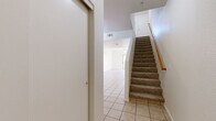 Located in Mesa, Arizona, this two-story, two-bedroom, two-bathroom home offers a functional and well-organized layout across two floors. The main level is the larger of the two floors and features light-filled, open living and dining areas with neutral-toned tile flooring and ceiling fans throughout. The kitchen is efficiently designed with warm wood cabinetry, dark granite-style countertops, black appliances including a refrigerator, range, and built-in microwave, plus a stainless steel sink beneath a window that brings in natural light. A breakfast bar peninsula connects the kitchen to the dining and living space, creating a seamless flow ideal for everyday living. A staircase with a wood handrail and carpeted treads leads to the upper level, where the two bedrooms are situated. The primary bedroom offers a comfortable footprint with plush carpet, a ceiling fan, and a window with vertical blinds. Both bathrooms feature wood-look vinyl flooring, vanities with light-toned cabinetry, and a combination tub/shower. Six closets throughout the home provide generous storage. A patio completes the space, offering outdoor access. The home maintains a clean, neutral palette throughout.