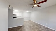 This efficiently designed 1-bedroom, 1-bathroom unit offers a practical and comfortable single-floor layout. The open-concept living and kitchen area forms the heart of the space, where durable wood-look flooring and a textured ceiling with a ceiling fan with integrated light fixture create a functional, cohesive atmosphere. Neutral gray walls throughout provide a clean, versatile backdrop.

The kitchen is defined by a peninsula-style breakfast bar that separates it from the living area, white cabinetry offering ample storage, light-toned countertops, and black appliances including a gas range and refrigerator. The living area benefits from a ceiling fan and flows naturally from the kitchen.

The bedroom is a well-proportioned room featuring wood-look flooring, a window with blinds that brings in natural light, a textured ceiling, and a ceiling fan. A set of sliding panel closet doors opens to a reach-in closet with wire shelving, providing practical storage.

The bathroom is finished with white cabinetry, a light stone-pattern countertop with an integrated sink, brushed nickel fixtures, and a shower-tub combination. The unit's consistent use of neutral tones, wood-look flooring, and white trim throughout creates a clean, unified aesthetic.