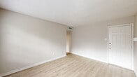 This two-bedroom, two-bathroom unit at 1400 Blue Bell Rd in Houston, Texas offers a well-organized single-level layout with a thoughtful mix of functional and inviting spaces. Light wood-look flooring runs throughout, complemented by neutral walls and textured ceilings that create a clean, cohesive aesthetic.

The living room serves as a standout feature, anchored by a floor-to-ceiling white-painted brick fireplace and a bank of windows that flood the room with natural light and outdoor views. The galley-style kitchen is efficiently designed with white cabinetry, quartz-style countertops, a double basin sink, and stainless steel appliances including a range, dishwasher, and refrigerator. A skylight adds additional brightness. Adjacent to the kitchen is a pantry, dining room, and utility room for added convenience.

Both bedrooms feature light wood-look flooring, ceiling fans with lighting, and closets. The spacious primary bedroom includes direct access to its own bathroom. Each bathroom is fitted with a tub-shower combination with tile surround, wood-look flooring, and white cabinetry. Hallways connect the rooms efficiently, rounding out a practical and comfortable floor plan well-suited for everyday living.