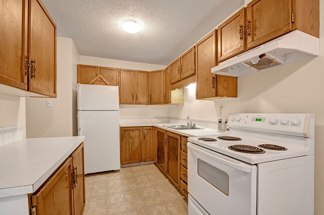 A kitchen with white appliances and light cabinetry - Broadmoor