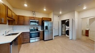 Located on the fifth floor at 1102 West Summit Parkway in Spokane, WA, Unit 501 is a thoughtfully designed residential unit offering a comfortable and functional layout. The open living area features light-toned flooring, neutral walls, and recessed lighting, creating a clean and airy atmosphere. A large, multi-pane window frames sweeping views of the Spokane cityscape, flooding the space with natural light.

The kitchen is a standout feature, outfitted with rich warm-toned wood cabinetry, light countertops, and a full suite of stainless steel appliances including a side-by-side refrigerator with ice maker, electric range, over-the-range microwave, and dishwasher. The layout is efficient, providing generous counter and storage space for everyday use. Conveniently positioned nearby is an in-unit utility closet housing a stacked washer and dryer alongside a water heater, adding significant practicality.

The bedroom is a quiet, carpeted retreat featuring a large window with city views, offering both comfort and natural brightness. The bathroom is finished with neutral tile flooring, a wood-toned vanity with a white countertop, a large mirror, and a full tub and shower combination. Recessed lighting throughout the unit contributes to a consistently polished and modern aesthetic. This unit combines urban convenience with functional design in a prime Spokane location.