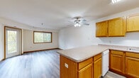Located at 12555 Pennock Ave in Apple Valley, Minnesota, this 2-bedroom, 2-bathroom single-floor home offers a well-organized and functional layout ideal for comfortable everyday living. The open-concept kitchen and living room serve as the heart of the home, featuring warm oak cabinetry, a central island with ample counter space, white appliances including a refrigerator and range, and hardwood-style flooring that flows throughout the main living areas. A ceiling fan with integrated lighting anchors the living space, which is brightened by a large window with views of surrounding greenery. A glass door leads directly to a private balcony, extending the living space outdoors with pleasant tree-lined views. The primary bedroom is generously sized with natural light streaming through a dedicated window and direct balcony access, while the second bedroom features plush carpeting and its own window overlooking the outdoors. Both bedrooms are supported by four closets throughout the home. The two bathrooms are finished with oak vanities and light countertops; one includes a full tub-shower combination. Hardwood-style flooring carries through the bathrooms and common areas, while carpet adds warmth to both bedrooms. An in-unit laundry area adds everyday convenience, rounding out this well-appointed home.