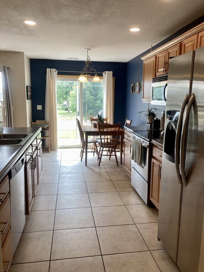 Cocina y comedor con acceso al patio. - 906 SE Crossings Ln