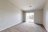 Located at 105 Landmark Dr in Council Bluffs, Iowa, this one-bedroom, one-bathroom unit offers a thoughtfully designed single-floor layout with a clean, modern aesthetic. The open-concept living area features vaulted ceilings that enhance the sense of space, soft carpeting underfoot, and a sliding glass door that opens to a private balcony, filling the room with natural light. A ceiling fan adds both comfort and style to the living space. The kitchen is well-equipped with white shaker-style cabinetry, white countertops, and a full suite of stainless steel appliances including a refrigerator, electric range, microwave, and dishwasher. Wood-look flooring and pendant lighting complete the kitchen's contemporary feel. The bedroom is a comfortable retreat with plush carpet, a ceiling fan, a large window with vertical blinds, and access to a dedicated walk-in closet outfitted with wire shelving for organized storage. The bathroom features wood-look flooring, a single-sink vanity with storage, a lighted mirror, a tub-shower combination, and black accent hardware throughout. Neutral tones and clean finishes lend the entire unit a cohesive, move-in-ready appearance.