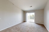 Located at 105 Landmark Dr in Council Bluffs, Iowa, this one-bedroom, one-bathroom unit offers a thoughtfully designed single-floor layout with a clean, modern aesthetic. The open-concept living area features vaulted ceilings that enhance the sense of space, soft carpeting underfoot, and a sliding glass door that opens to a private balcony, filling the room with natural light. A ceiling fan adds both comfort and style to the living space. The kitchen is well-equipped with white shaker-style cabinetry, white countertops, and a full suite of stainless steel appliances including a refrigerator, electric range, microwave, and dishwasher. Wood-look flooring and pendant lighting complete the kitchen's contemporary feel. The bedroom is a comfortable retreat with plush carpet, a ceiling fan, a large window with vertical blinds, and access to a dedicated walk-in closet outfitted with wire shelving for organized storage. The bathroom features wood-look flooring, a single-sink vanity with storage, a lighted mirror, a tub-shower combination, and black accent hardware throughout. Neutral tones and clean finishes lend the entire unit a cohesive, move-in-ready appearance.