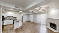Located at 2600 Ventura Dr in Plano, TX, this single-story residence offers three bedrooms and three bathrooms across a thoughtfully designed floor plan. The open-concept living and kitchen area serves as the heart of the home, highlighted by distinctive tray ceilings, a ceiling fan with light fixture, and warm wood-look flooring. Large windows and a sliding glass door with vertical blinds flood the living space with natural light and provide outdoor access. The kitchen features crisp white shaker cabinetry, granite countertops, a coordinating granite-topped breakfast bar, and black Whirlpool appliances including a refrigerator, range, and over-the-range microwave. The bedrooms are carpeted and finished with crown molding and ceiling fans, offering a comfortable retreat. The primary bathroom is well-appointed with a floating white vanity, granite countertop, a large framed mirror with brushed nickel hardware, wood-look flooring, and a tiled soaking tub and shower surround. Additional bathrooms feature tiled tub-shower combinations. Generous closet space includes walk-in closets equipped with wire shelving systems. A dedicated laundry area and hallway complete this efficiently designed, move-in-ready home.