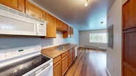 Located at 7646 Highlands View Rd in Truckee, California, this single-floor unit offers a efficiently organized layout comprising a kitchen, bathroom, and open living area. Throughout the space, warm hardwood-style flooring creates a cohesive and inviting aesthetic that ties each area together seamlessly.

The main living area features neutral-toned walls, a flush-mount ceiling light, and baseboard heating, ensuring comfort during Truckee's colder mountain seasons. Windows fitted with horizontal blinds allow natural light to filter in while framing views of the surrounding forested landscape.

The kitchen is well-equipped with warm oak cabinetry, laminate countertops, a stainless steel sink, and white appliances including a range, refrigerator, microwave, and dishwasher. Track lighting overhead illuminates the workspace effectively. A peninsula-style counter partially separates the kitchen from the living area, enhancing the sense of openness.

The bathroom continues the hardwood-style flooring and features a wood-toned vanity with a single sink, a large mirror, and a shower area. The neutral wall tones maintain a clean, understated look throughout. Overall, the unit presents a functional and straightforward design suited to the mountain setting of Truckee.