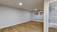 Located on South Drexel Boulevard in Chicago's Woodlawn neighborhood, this efficiently designed studio offers a thoughtfully updated interior across a single floor. Light oak-toned luxury vinyl plank flooring runs seamlessly throughout the entire space, lending warmth and visual continuity to every room.

The open-plan living, dining, and kitchen area maximizes the available footprint. The kitchen is outfitted with stainless steel appliances — including a refrigerator, range, and microwave — complemented by two-tone cabinetry featuring white uppers and gray lowers, a white subway tile backsplash, and a single-basin sink. Recessed lighting and a flush ceiling fixture keep the kitchen well-lit.

The living and dining area is bright and clean, with light gray walls, crisp white baseboards, and windows dressed with woven shades that allow natural light to filter in. Baseboard heating units run along the walls, and recessed ceiling lights provide additional illumination throughout.

The full bathroom is finished with large-format gray wall tile surrounding a soaking tub with shower, a gray vanity with a black-fixture faucet, a framed mirror, and consistent wood-look flooring. A dedicated closet provides convenient storage. The overall aesthetic is clean, modern, and move-in ready.