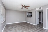 Located at 1200 Kingstown Ct in Albany, Georgia, this single-floor unit offers a straightforward and functional layout designed for comfortable everyday living. Throughout the main living areas and bedroom, wood-look plank flooring provides a cohesive and easy-to-maintain surface, complemented by neutral gray walls and crisp white baseboards that create a clean, understated aesthetic. Textured ceilings with ceiling fans are found in key rooms, adding to the practical character of the space.

The living area is open and well-proportioned, featuring a pass-through window that connects directly to the kitchen, enhancing the flow between spaces. A exterior door with a paneled design and a window with blinds allow natural light to fill the room. The kitchen is equipped with white upper and lower cabinetry, dark countertops, a stainless steel sink, and an overhead range hood, providing ample storage and workspace for daily meal preparation.

The bedroom is generously sized and includes a sliding-door closet with built-in shelving, a built-in vanity countertop with a mirror and vanity lighting, and a ceiling fan overhead. The full bathroom features tile flooring, a vanity with under-sink cabinet storage, a mirror with overhead lighting, a toilet, and a tub-shower combination, rounding out the functional amenities of this well-appointed unit.