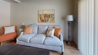 This single-floor residence offers a thoughtfully designed open-concept layout that seamlessly connects the kitchen, dining, and living areas. The kitchen is a standout feature, equipped with rich dark espresso cabinetry, granite countertops, black appliances including a full-size refrigerator, electric range, and built-in microwave, as well as a central island with bar seating — ideal for casual dining or meal prep. Warm hardwood-style flooring extends throughout the main living areas, complementing the kitchen's bold, contemporary aesthetic.

The dining area flows naturally into the living room, which offers a comfortable, open atmosphere with neutral wall tones and access to a sliding glass door that invites natural light. The living room provides ample space for seating and relaxation.

The bedrooms are carpeted for comfort and each features large windows that allow generous natural light. The rooms offer a calm, neutral palette with enough space for full or queen-sized furnishings.

The bathroom is finished with tile flooring and includes a full tub-shower combination. Throughout the residence, the design balances practicality with a clean, modern sensibility, making it a functional and inviting living space.