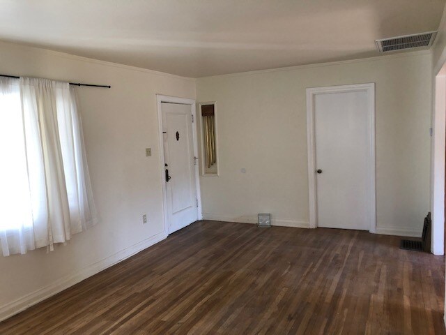 Sala de estar con vista a la puerta principal a la izquierda, puerta del segundo dormitorio a la derecha. - 10516 Blythe Ave