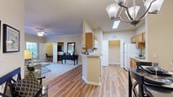 Located in D'Iberville, Mississippi, this single-story 2-bedroom, 2-bathroom residence offers a thoughtfully designed layout with a warm, neutral color palette throughout. The living room features crown molding, a ceiling fan, and large windows that invite an abundance of natural light, creating a bright and welcoming atmosphere. Adjacent to the living area, the dining room showcases hardwood-style flooring and an elegant chandelier, flowing seamlessly toward the entrance for an open, connected feel. The galley-style kitchen is equipped with warm wood cabinetry, white appliances, a pantry, and hardwood-style flooring, offering ample storage and counter space. The generously sized primary bedroom includes a built-in fireplace with tile surround, a dedicated built-in workspace, a ceiling fan, and access to a spacious walk-in closet with wire shelving. The second bedroom is carpeted and benefits from multiple windows and its own closet. Both bathrooms feature warm wood vanities, tile flooring, and tub-shower combinations. Additional highlights include four closets for exceptional storage, a dedicated laundry area, and a private patio with views of lush greenery — ideal for relaxing outdoors.