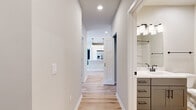 Located at 1211 Carrington Blvd in Mount Pleasant, WI, this 1,100-square-foot single-floor home offers 2 bedrooms and 2 bathrooms with a clean, modern aesthetic. The open-concept kitchen features white shaker cabinetry, stainless steel appliances, a large center island with a white countertop and pendant lighting, and light hardwood flooring that flows throughout the main living areas. Both bathrooms are finished with gray vanity cabinetry, white countertops, and sleek matte black hardware and fixtures, complemented by light hardwood floors. The primary bedroom measures 180 square feet and includes plush carpeting and access to a spacious walk-in closet equipped with wire shelving systems. The second bedroom also features soft carpet flooring and large windows that flood the room with natural light and open views of the surrounding landscape. A convenient stacked washer and dryer unit is accessible from the secondary bedroom area. Two closets provide ample storage throughout the home. Neutral wall tones and crisp white trim create a bright, cohesive ambiance, making this home a versatile and move-in-ready space.