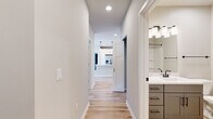 Located at 1211 Carrington Blvd in Mount Pleasant, WI, this 1,100-square-foot single-floor home offers 2 bedrooms and 2 bathrooms with a clean, modern aesthetic. The open-concept kitchen features white shaker cabinetry, stainless steel appliances, a large center island with a white countertop and pendant lighting, and light hardwood flooring that flows throughout the main living areas. Both bathrooms are finished with gray vanity cabinetry, white countertops, and sleek matte black hardware and fixtures, complemented by light hardwood floors. The primary bedroom measures 180 square feet and includes plush carpeting and access to a spacious walk-in closet equipped with wire shelving systems. The second bedroom also features soft carpet flooring and large windows that flood the room with natural light and open views of the surrounding landscape. A convenient stacked washer and dryer unit is accessible from the secondary bedroom area. Two closets provide ample storage throughout the home. Neutral wall tones and crisp white trim create a bright, cohesive ambiance, making this home a versatile and move-in-ready space.