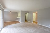 Located at 48 Washington St in Santa Clara, CA, this single-floor residence offers three bedrooms and two bathrooms with a thoughtfully designed, functional layout. The open-concept living room and kitchen area serves as the heart of the home, featuring neutral gray walls, plush wall-to-wall carpeting, and large sliding glass doors that flood the space with natural light and provide direct access to a patio overlooking a well-maintained green courtyard. A ceiling fan adds practical comfort to the living area.

The kitchen is efficiently appointed with white cabinetry, a clean white countertop peninsula with a built-in sink, stainless steel appliances including a refrigerator, electric range with over-the-range microwave, and a dishwasher, all set over warm hardwood-style flooring. The peninsula opens toward the living area, creating a connected and sociable flow.

The generously sized primary bedroom includes a walk-in closet with built-in shelving and carpeted floors, while the additional bedrooms are bright and comfortable, each with carpet and windows allowing natural light. Both bathrooms are clean and modern, featuring white vanities with ample counter space, large mirrors, and hardwood-style flooring. The overall aesthetic throughout is clean, neutral, and move-in ready.