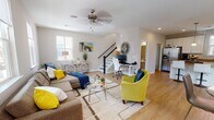 Located at 198 Village Center Blvd in Myrtle Beach, SC, this two-story home offers a thoughtfully designed layout across two levels. The main floor welcomes you with a bright, open-concept living area finished with light hardwood flooring and large windows that invite ample natural light. The living room provides generous space for both lounging and a dedicated workspace, complete with a ceiling fan overhead. Adjacent to the living area, the kitchen is a standout feature, boasting white shaker cabinetry, gleaming granite countertops, stainless steel appliances, and a central island with bar seating — ideal for casual dining or entertaining. A half bath with hardwood flooring is also conveniently located on the main level. Upstairs, the primary bedroom is a serene retreat featuring plush carpeting, a tray ceiling, dual windows with plantation shutters, and direct access to a private en-suite bathroom with granite countertops, white cabinetry, and a tub-shower combination. An additional bedroom and full bathroom with granite countertops complete the upper level. Throughout the home, neutral tones and clean finishes create a cohesive, modern ambiance well-suited for comfortable living in the heart of Myrtle Beach.