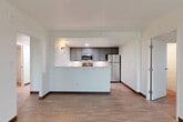 Located at 3155 S Vaughn Way in Aurora, CO, this single-floor, one-bedroom, one-bathroom unit offers a thoughtfully designed layout across a generously sized floor plan. Light wood-style flooring runs throughout, complemented by crisp white walls and dark wood baseboards that create a clean, modern aesthetic.

The open-concept kitchen and living area serves as the heart of the unit. The kitchen is outfitted with dark gray shaker-style cabinetry extending to the ceiling for ample storage, stainless steel appliances including a refrigerator, range, and microwave, and a light-colored countertop peninsula that doubles as a breakfast bar. Recessed and wall-mounted lighting adds warmth to the space.

The living room flows seamlessly from the kitchen, offering generous open space. A hallway connects the main living areas to the private spaces, featuring a granite-topped counter niche and access to the electrical panel.

The spacious primary bedroom benefits from a large window that fills the room with natural light and frames views of the surrounding Aurora landscape. A closet provides dedicated storage. The full bathroom includes a gray vanity with a white countertop, a tub/shower combination with a curved rod, and matching flooring that ties the space together cohesively.