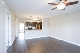 This single-floor residence offers a thoughtfully designed layout that balances comfort and functionality throughout. The open-concept living and dining area is anchored by durable wood-style plank flooring, a ceiling fan with integrated lighting, and a glass door that invites natural light while providing outdoor access. The space flows seamlessly into the kitchen, which features a raised breakfast bar, rich dark cabinetry, granite-style countertops, and a full suite of stainless steel appliances including a gas range, refrigerator, dishwasher, and microwave. The bedrooms are finished with plush wall-to-wall carpeting and ceiling fans, each benefiting from natural light through blinds-fitted windows. The primary bedroom connects directly to a private en-suite bathroom outfitted with wood-style flooring, a dark vanity with stone countertops, and a walk-in shower. A second full bathroom mirrors this quality with a soaking tub and sliding glass enclosure. A generous walk-in closet features wire shelving and hanging rods, providing ample storage. Clean white walls and consistent finishes throughout give the residence a bright, cohesive aesthetic.