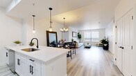 This contemporary 1,030 square foot home in Centennial, Colorado offers a harmonious blend of style and functionality. The single-story layout comprises three bedrooms and three bathrooms, with the primary bedroom boasting a generous 190 square feet. The heart of the home is an open-concept living area that combines the kitchen, dining room, and living room, creating a seamless flow for everyday living and entertaining.

The kitchen is a standout feature, showcasing sleek white cabinetry, stainless steel appliances, and a practical island with seating. Modern pendant lighting adds a touch of elegance, while the overall design maintains a clean, minimalist aesthetic. The dining area, adorned with a stylish chandelier and a round wooden table, offers a cozy spot for meals.

Throughout the home, light-toned wood flooring and crisp white walls create a bright, airy atmosphere. Large windows in the living room and bedrooms allow ample natural light to flood the space, while also offering views of the surrounding area. The bathrooms are thoughtfully designed with contemporary fixtures, including curved shower rods and sleek vanities.

The bedrooms are well-appointed, with the primary bedroom featuring calming blue accents and ample space for a king-sized bed. Built-in closets and additional storage solutions, such as the utility room, ensure that the home remains clutter-free and organized.

Overall, this property presents a modern, low-maintenance living option with its efficient use of space and updated amenities, perfect for those seeking a contemporary lifestyle in the heart of Centennial.