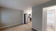 Located at 414 South 4th Street in San Jose, California, this 2-bedroom, 1-bathroom apartment offers a practical and well-organized single-floor layout. The living room is finished with neutral-toned carpet and connects seamlessly to the kitchen, creating an open and functional flow. The kitchen is a standout feature, equipped with crisp white shaker cabinetry, light quartz-style countertops, stainless steel appliances including a refrigerator, range, microwave, and dishwasher, and light wood-look flooring that adds warmth to the space. A window above the sink allows for natural light throughout the day. The bedrooms are carpeted and restful, with the primary bedroom offering ample space and a mirrored sliding-door closet that enhances the sense of openness. Windows with blinds bring in natural light while maintaining privacy. The bathroom is clean and efficient, featuring a tub and shower combination with sliding glass doors, a white vanity, and wood-look vinyl flooring. Additional highlights include three closets for generous storage, a dedicated laundry area, and a connecting hallway that ties the layout together. The unit's neutral gray and beige color palette throughout creates a calm, move-in-ready atmosphere.