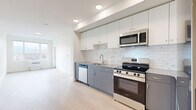 This contemporary apartment in Kelowna offers 66 square meters of well-designed living space. The open-concept layout maximizes efficiency, featuring two bedrooms and two bathrooms. The kitchen is a highlight, boasting sleek two-tone cabinetry in white and gray, stainless steel appliances, and a striking marble-patterned backsplash. Light wood-look flooring runs throughout, creating a cohesive and bright atmosphere.

Large windows in the bedrooms and living areas flood the space with natural light and provide stunning city views. The primary bedroom, measuring 10 square meters, offers ample space and includes a closet with wire shelving. The bathrooms are modern and functional, with one featuring a glass-enclosed shower.

The apartment's design emphasizes clean lines and a neutral color palette, creating a fresh and inviting ambiance. Recessed lighting in the kitchen adds to the contemporary feel. This single-floor dwelling combines style and practicality, ideal for those seeking a modern urban lifestyle in Kelowna.