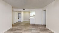Located at 15082 N 59th Ave in Glendale, Arizona, this two-bedroom, two-bathroom single-floor unit offers a practical and clean layout designed for comfortable everyday living. Wood-look plank flooring runs throughout the home, providing a cohesive and easy-to-maintain surface across all rooms.

The living room serves as the heart of the unit, featuring a ceiling fan with light fixture, a large window with vertical blinds that brings in natural light, and direct access to the front entry. The open layout connects seamlessly to the kitchen, which features white cabinetry with ample upper and lower storage, white appliances including a refrigerator, dishwasher, and electric range, a sink with a breakfast bar peninsula that opens to the living area, and a built-in overhead light.

A dedicated in-unit laundry closet accommodates a stacked washer and dryer, adding a notable convenience. Both bedrooms are bright and neutral, with clean white walls and the same wood-look flooring, each equipped with a closet for storage.

The two bathrooms are identically appointed with white tub-shower combinations, matching chrome fixtures, and wood-look flooring, presenting a clean and uniform aesthetic. The textured ceilings and neutral color palette throughout give the space a simple, move-in-ready character.