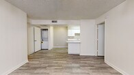 Located at 15082 N 59th Ave in Glendale, Arizona, this two-bedroom, two-bathroom single-floor unit offers a practical and clean layout designed for comfortable everyday living. Wood-look plank flooring runs throughout the home, providing a cohesive and easy-to-maintain surface across all rooms.

The living room serves as the heart of the unit, featuring a ceiling fan with light fixture, a large window with vertical blinds that brings in natural light, and direct access to the front entry. The open layout connects seamlessly to the kitchen, which features white cabinetry with ample upper and lower storage, white appliances including a refrigerator, dishwasher, and electric range, a sink with a breakfast bar peninsula that opens to the living area, and a built-in overhead light.

A dedicated in-unit laundry closet accommodates a stacked washer and dryer, adding a notable convenience. Both bedrooms are bright and neutral, with clean white walls and the same wood-look flooring, each equipped with a closet for storage.

The two bathrooms are identically appointed with white tub-shower combinations, matching chrome fixtures, and wood-look flooring, presenting a clean and uniform aesthetic. The textured ceilings and neutral color palette throughout give the space a simple, move-in-ready character.