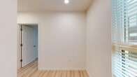 Located at 2133 North Argyle Street in Portland, Oregon, this two-bedroom, one-bathroom unit offers a well-organized single-floor layout designed for efficient, comfortable living. Light hardwood-style flooring runs throughout, lending a clean and cohesive look to every room.

The combined kitchen and living area serves as the heart of the unit. The kitchen is outfitted with rich dark wood cabinetry, light countertops, a stainless steel sink, and white appliances including a refrigerator, electric range, and dishwasher. Recessed lighting brightens the space, while a window brings in natural light. The adjacent living area features a ceiling fan and a large corner window arrangement that floods the room with daylight and offers views of the surrounding Portland neighborhood.

The primary bedroom is a comfortable, well-proportioned room with a ceiling fan, a built-in closet with shelving, and access to the hallway. The second bedroom also includes a ceiling fan and built-in closet space, maintaining consistent finishes throughout. Both bedrooms benefit from the unit's clean, neutral palette.

The bathroom is straightforward and functional, featuring a full tub-shower combination, toilet, and vanity with light hardwood-style flooring continuing from the rest of the unit. A hallway and dedicated closet provide additional storage throughout this efficiently designed Portland home.