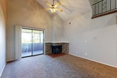 Located at 3323 S 56th St in Omaha, Nebraska, this two-story, one-bedroom, one-bathroom residence offers a well-designed layout across two distinct levels. The main floor serves as the heart of the home, anchoring an open living room and kitchen combination. The living room immediately impresses with soaring vaulted ceilings, a ceiling fan, and a corner brick fireplace that adds warmth and character. Sliding glass doors lead to a private balcony, inviting natural light and outdoor views into the space. The kitchen features white cabinetry, white appliances including a range, dishwasher, and refrigerator, complemented by light countertops and wood-look flooring for a clean, cohesive look. Carpeting flows throughout the living areas, adding comfort underfoot. A staircase with decorative wrought iron railings leads to the upper level, which opens to a loft-style landing overlooking the main floor. The spacious primary bedroom is found on this level, offering a ceiling fan, a natural light window, and a full sliding-door closet. The bathroom is outfitted with a full tub-shower combination, wood-look flooring, a white vanity, and built-in shelving, providing functional storage. This thoughtfully arranged two-story residence delivers a comfortable and characterful living experience.