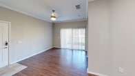This 550 square foot apartment in League City, TX, offers a thoughtfully designed living space on a single floor. The open-concept layout maximizes the available area, seamlessly blending the kitchen and living room. The kitchen features modern stainless steel appliances, including a refrigerator and range, complemented by white cabinetry and light-colored countertops.

The living area boasts rich, wood-look flooring and ample natural light through a large sliding glass door, which likely leads to a small balcony or patio. Crown molding adds a touch of elegance to the space. The bedroom, measuring 140 square feet, provides a cozy retreat with plush carpeting and a sizable window with blinds for privacy.

The bathroom is efficiently designed with a shower/tub combination, modern vanity, and continued wood-look flooring for a cohesive aesthetic. Additional features include a closet for storage and neutral paint colors throughout, creating a bright and inviting atmosphere. This apartment is well-suited for individuals or couples seeking a compact yet comfortable living space with contemporary finishes.