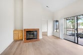 Located at 2680 E Highland Ave in San Bernardino, CA, this one-bedroom, one-bathroom unit offers a thoughtfully laid-out single-floor plan with a comfortable and functional design. The living room is an inviting space highlighted by soaring vaulted ceilings, a ceiling fan with light fixture, and a sliding glass door that opens to a private balcony with views of the surrounding neighborhood. An additional window further fills the room with natural light and contributes to its open, airy ambiance. Light wood-style flooring runs throughout the unit, providing a clean and cohesive look. A tiled fireplace with a built-in wood cabinet surround adds warmth and character to the living area. The kitchen features warm wood cabinetry, granite-style countertops, a stainless steel sink, and a skylight that brings in additional natural light. It is equipped with a dishwasher and range, with ample cabinet storage. The spacious bedroom offers a large window with neighborhood views and connects to a dedicated closet with built-in shelving and hanging rods. The bathroom includes a granite-style vanity countertop, a wood-framed cabinet base, a large mirror, and a shower-tub combination.