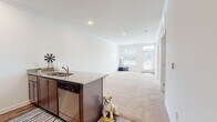 Located at 321 E Park Rd in Indian Trail, NC, this single-floor residence offers a well-designed layout that combines comfort and functionality. The open-concept kitchen and living area serves as the heart of the home, where rich dark-cabinetry kitchen flows seamlessly into the living space. The kitchen is equipped with a full suite of stainless steel appliances, including a range, microwave, and refrigerator, complemented by granite countertops and a kitchen island with a double sink. Hardwood-style flooring anchors the kitchen and dining area, while plush wall-to-wall carpeting extends throughout the living room and bedrooms, adding warmth underfoot. Crown molding and recessed lighting provide refined finishing touches throughout. The spacious living area is bathed in natural light from large windows fitted with blinds. The bedrooms are generously sized and bright, each featuring carpeted floors and windows that invite in natural light. The bathroom is appointed with a wood-toned vanity, white countertop, a large mirror, and hardwood-style flooring, delivering a clean and modern aesthetic. Overall, this residence presents a bright, neutral palette and practical layout well-suited for comfortable everyday living in Indian Trail, NC.