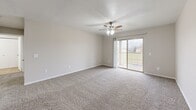 Located at 2752 S Meadowbrook Ave in Springfield, MO, this one-bedroom, one-bathroom unit offers a practical and comfortable layout designed for everyday living. The open-concept living and kitchen area forms the heart of the home, with plush carpeting and a ceiling fan with light fixture anchoring the living space. Sliding glass doors lead to a private balcony, allowing natural light to fill the room and offering pleasant outdoor views. The kitchen is well-appointed with rich dark-brown cabinetry, light granite-style countertops, a peninsula with an undermount sink, and white appliances including a refrigerator, electric range, built-in microwave, and dishwasher. Tile flooring runs throughout the kitchen for easy maintenance. The generously sized bedroom features soft carpeting, a ceiling fan, a natural light-admitting window, and a closet, providing a restful retreat. The full bathroom includes a dark-wood vanity with a granite-style countertop, a lighted mirror, tile flooring, and a tub-shower combination. Additional highlights include multiple closets for ample storage, a dedicated laundry area, and a utility room, rounding out a thoughtfully functional living space.