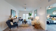 Located in Lutz, Hillsborough County, Florida, this single-story residence on Osprey Nest Loop offers a thoughtfully designed open-concept floor plan with contemporary finishes throughout. The bright and airy living room is anchored by wood-look plank flooring, a ceiling fan, and large French doors that invite abundant natural light. The space flows seamlessly into a dedicated dining area accented by coastal-inspired artwork and a rattan dining set, creating a warm and inviting atmosphere.

The galley-style kitchen is well-equipped with white shaker cabinetry, granite countertops, stainless steel appliances, and light wood-look flooring. A kitchen island with bar seating provides an additional gathering and prep area, enhancing both function and flow.

The primary bedroom features plush carpeting, a teal accent wall, a ceiling fan, and multiple windows that brighten the space. A second bedroom offers similar comfort with soft carpeting and coordinating accent wall tones. Both bathrooms are finished with granite-topped white vanities, light wood-look flooring, and full tub-shower combinations with tile surrounds. Clean white cabinetry and neutral palettes give both bathrooms a crisp, modern feel throughout.