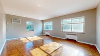 Located at 2229 Victory Pkwy in Cincinnati's vibrant East Walnut Hills neighborhood, this single-floor, 2-bedroom, 1-bathroom residence offers a well-organized layout with a comfortable and functional living environment.

The spacious living room is a standout feature, bathed in abundant natural light streaming through multiple large windows that offer pleasant views of surrounding greenery. Classic parquet hardwood flooring runs throughout the main living areas and bedrooms, adding warmth and timeless character to the space. Baseboard radiators provide efficient heating throughout.

The kitchen is outfitted with stainless steel appliances — including a gas range, over-the-range microwave, dishwasher, and refrigerator — complemented by rich, dark wood cabinetry and light tile flooring. An elegant arched doorway connects the kitchen area to the rest of the unit.

Both bedrooms continue the parquet flooring theme and offer ample natural light through multiple windows. The primary bedroom includes a ceiling fan and a wall-mounted air conditioning unit. Multiple closets throughout the unit provide generous storage options.

The bathroom features clean white subway tile walls, a glass-enclosed shower, and a window for natural ventilation. Two hallways help define distinct zones within the home, contributing to an efficient and comfortable flow throughout the space.